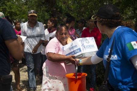 Una mujer recibe despensas en Tabasco.